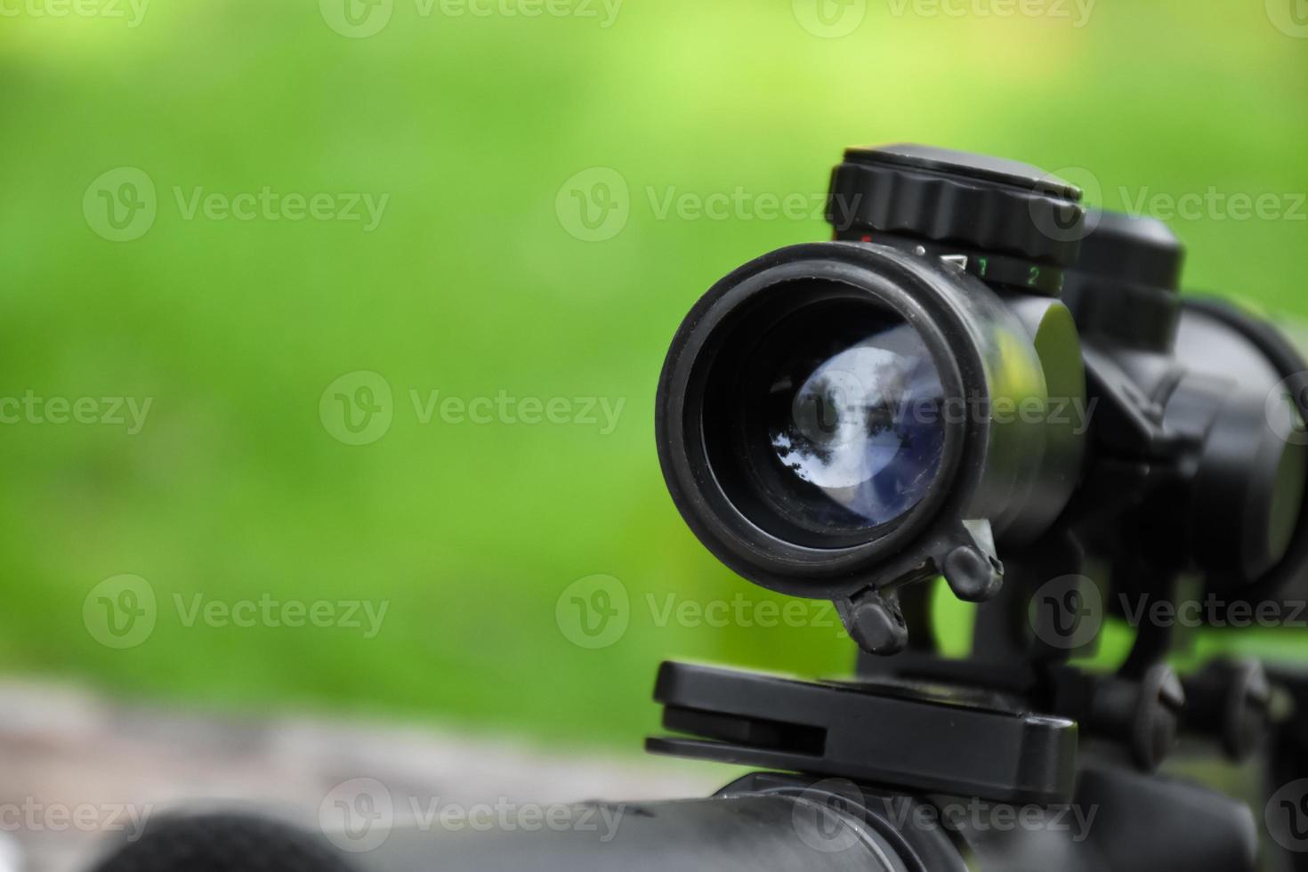 Binoculars of black automatic rifle Long-barreled at the training ground, also known as Air Soft or BB Gun. Use bullets made with spherical plastic beads. Soft and selective focus on binoculars. photo