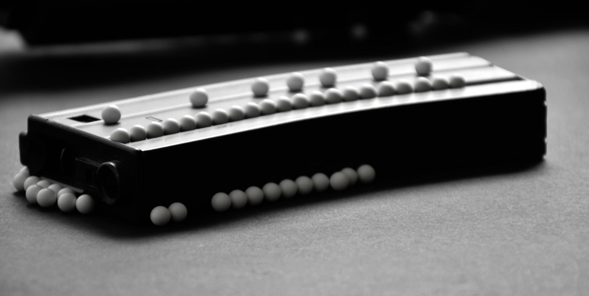 White plastic bullet balls of airsoft gun or bb gun on dark floor soft and selective focus on white pellets. photo