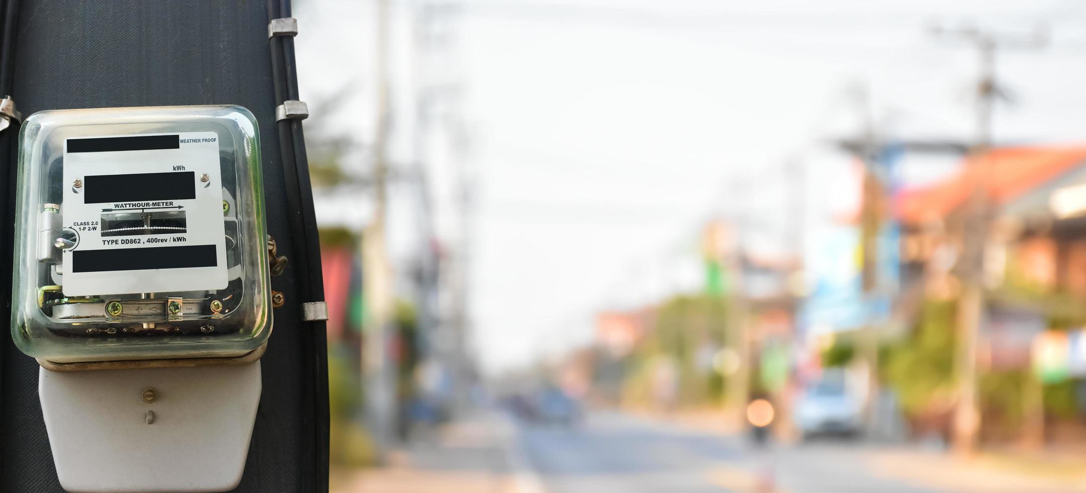 Watthour meter or electricity meter on pole to record the monthly electricity consumption of the inhabitants of each houses in the Southeast Asian countries, soft and selective focus on meter. photo