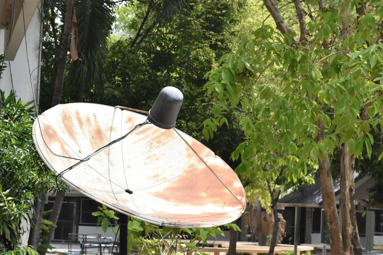 An old c-band satellite dish installed on the mountain in remote areas of Asian countries to receive tv and radio signal from sattellite station in the city. photo