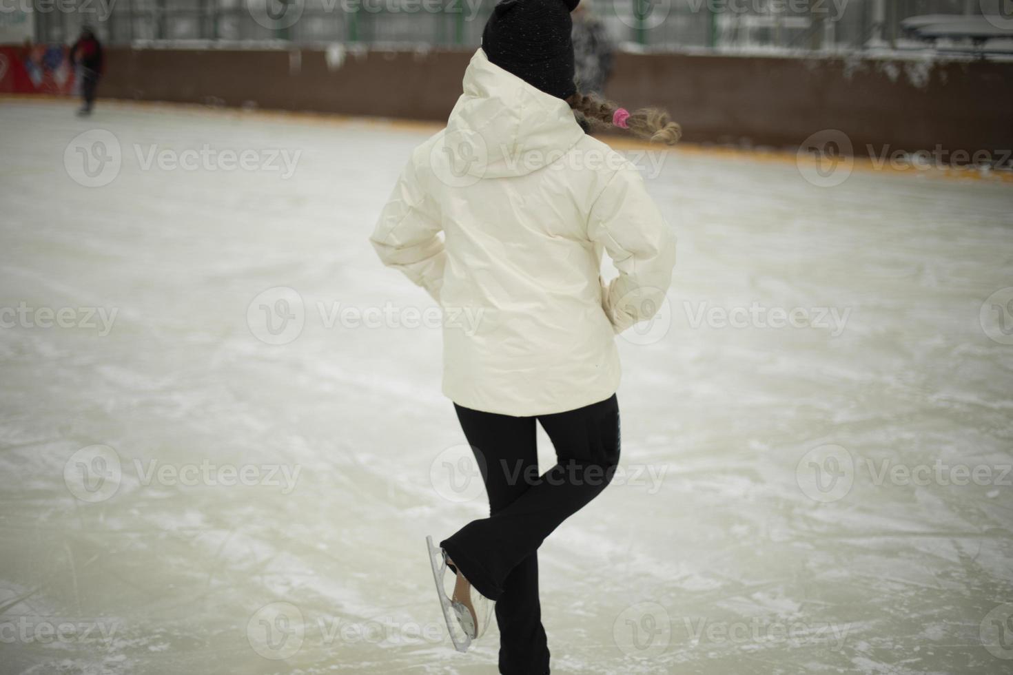 Girl on skates. Winter holidays. Ice skating. Sports details. Exercise on ice. photo