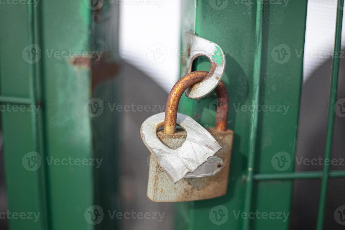 The castle hangs on the gate on the street. Closed door. Private property protection. photo