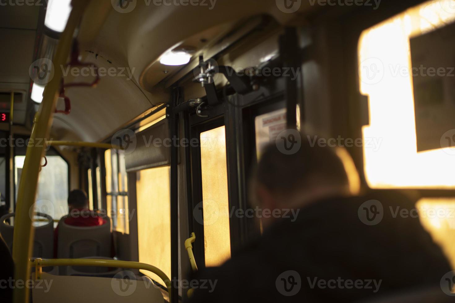 Inside bus is light of sun. People in transport. photo