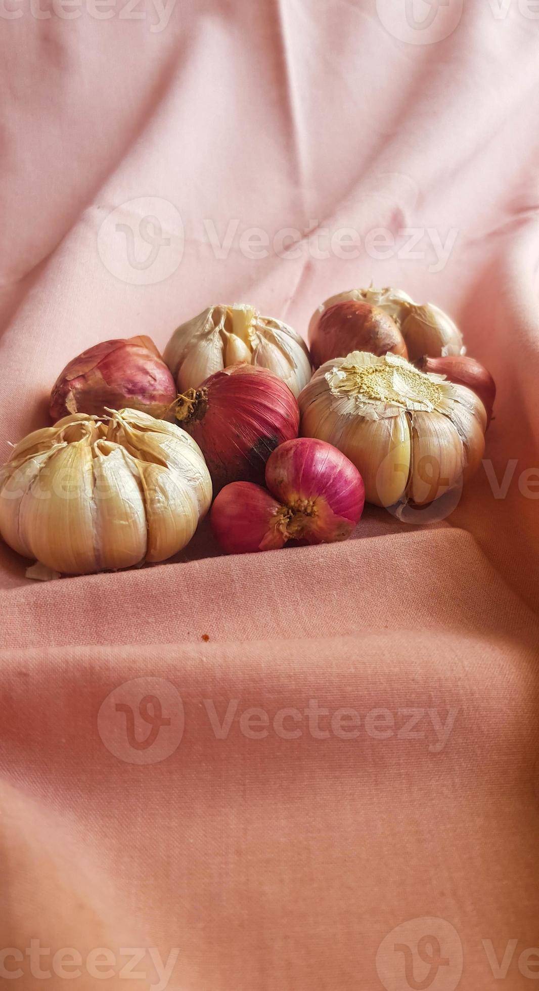 This is a photo of some cloves of garlic and onion or shallots placed