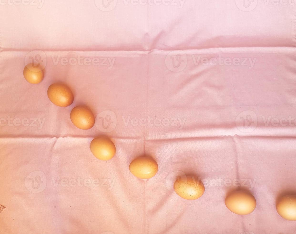 Some eggs are laid on a pink cloth. photo