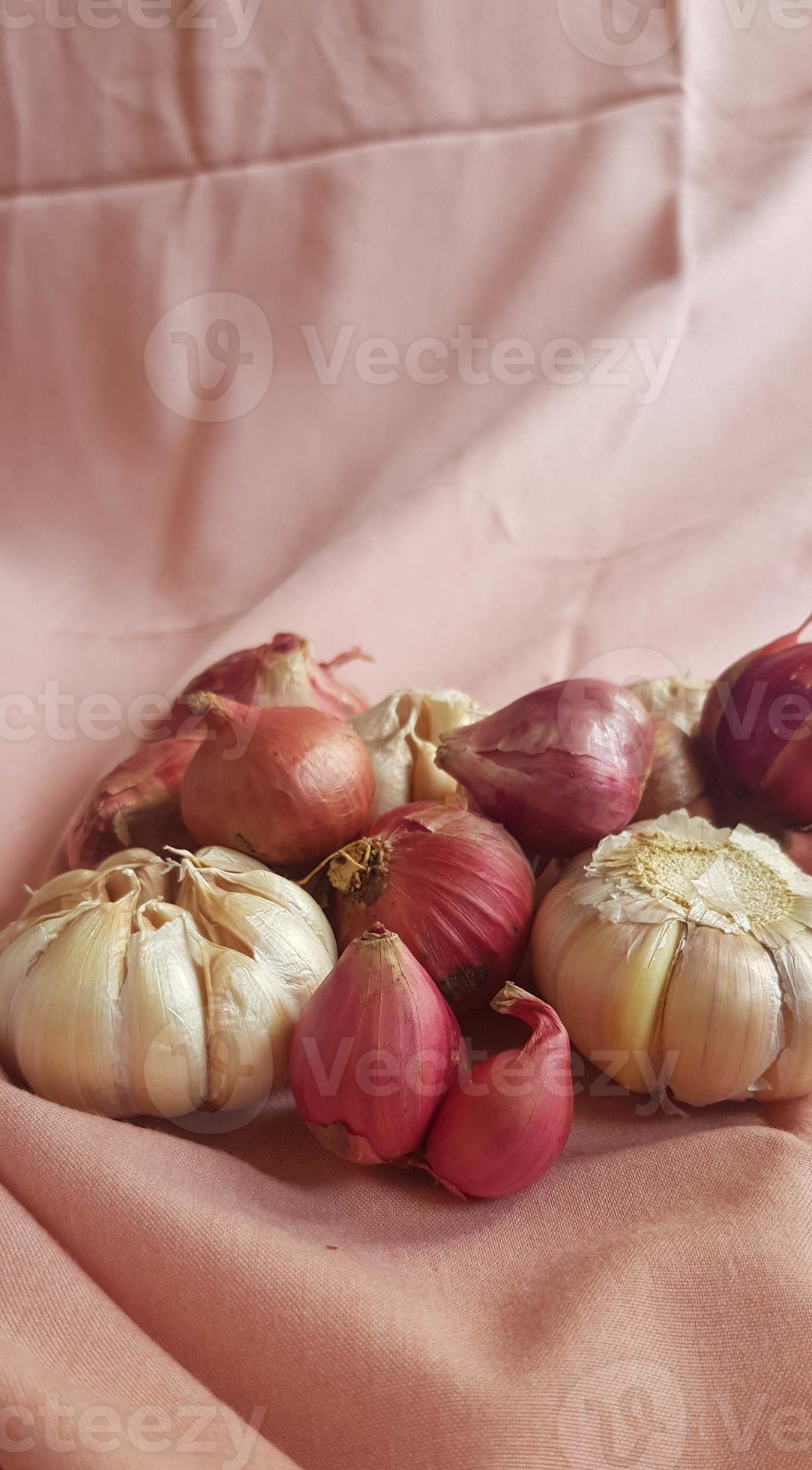 This is a photo of some cloves of garlic and onion or shallots placed
