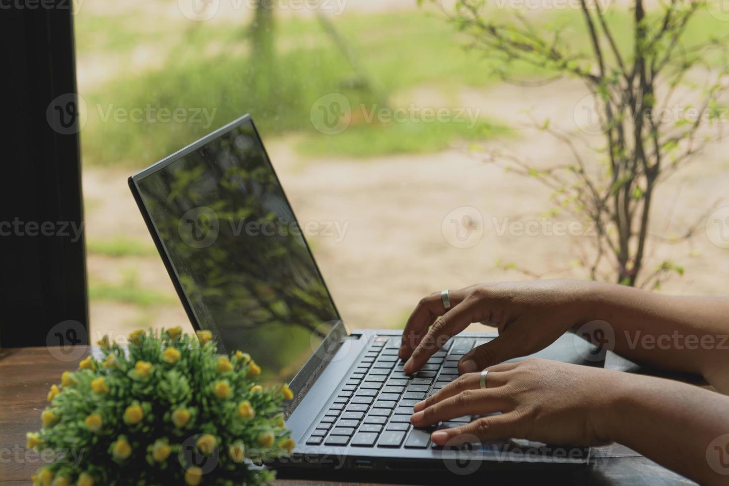 A woman working on a laptop with a black screen. photo