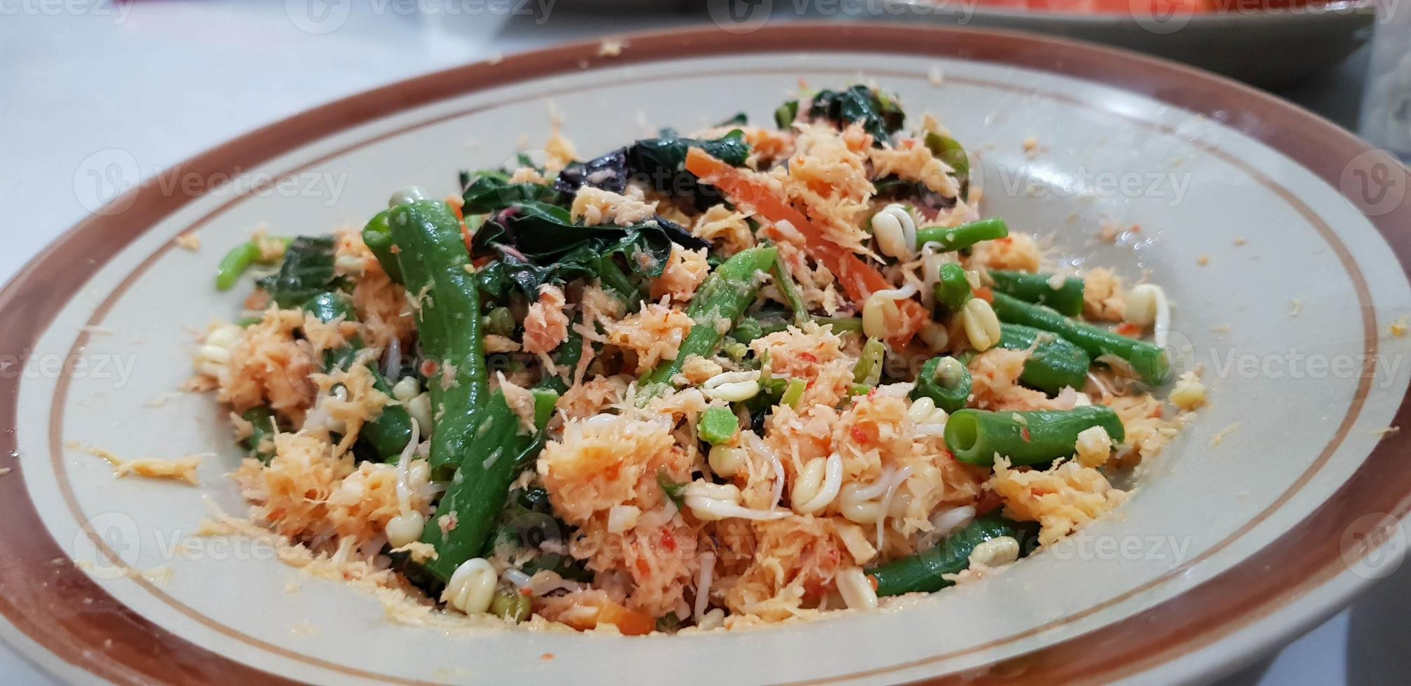 urap es una comida tradicional en forma de ensalada que consiste en verduras hervidas con coco rallado picante salteado. foto