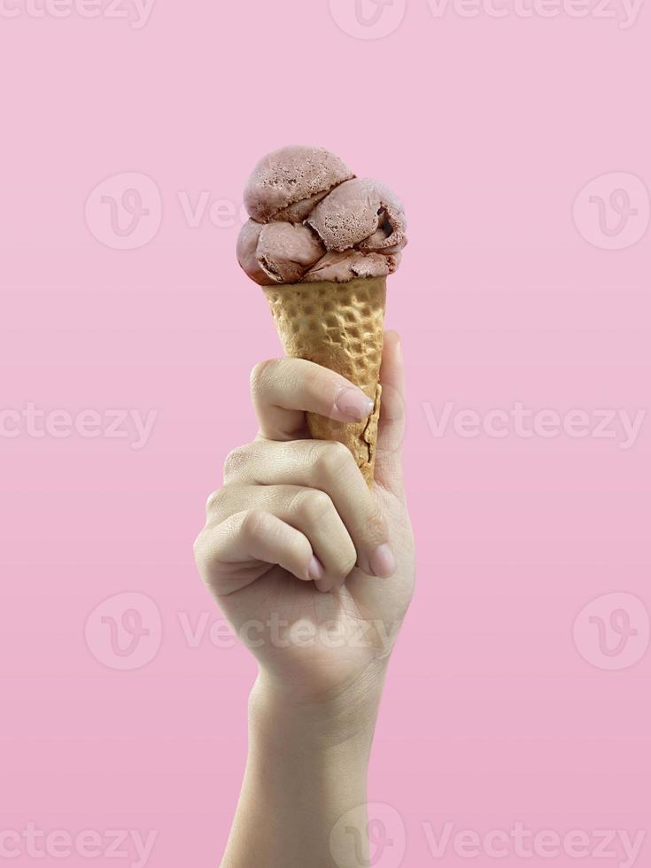 Ice cream cone on pink background, woman holding ice cream by hand photo