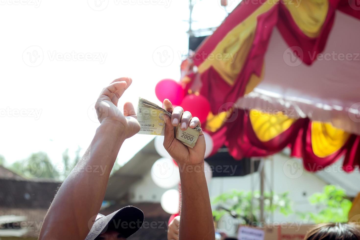 A person's hand holding banknotes or Indonesian state money photo