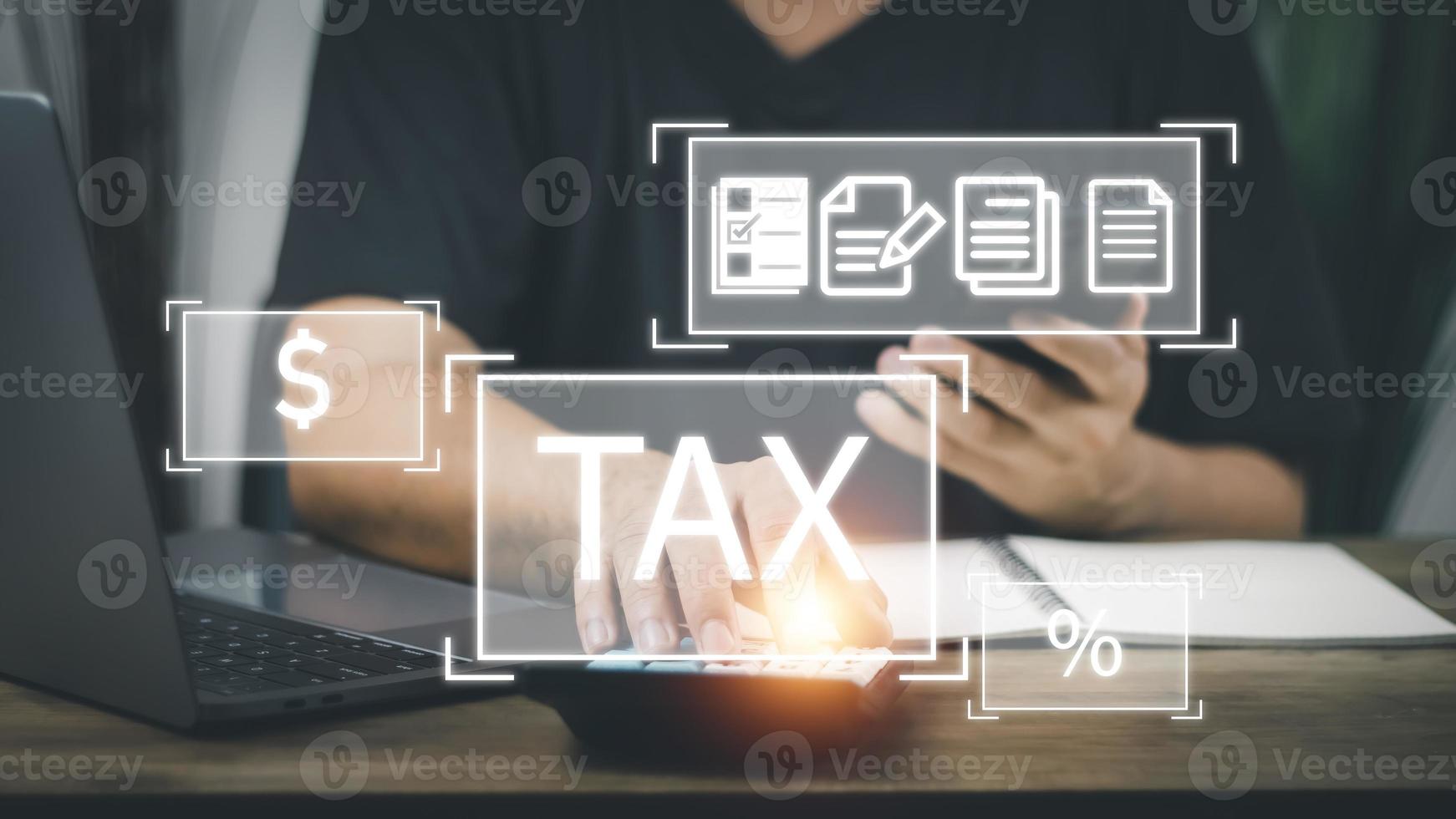 Financial tax return concept, a man's hand using a smartphone and a computer to work in accounting and tax photo