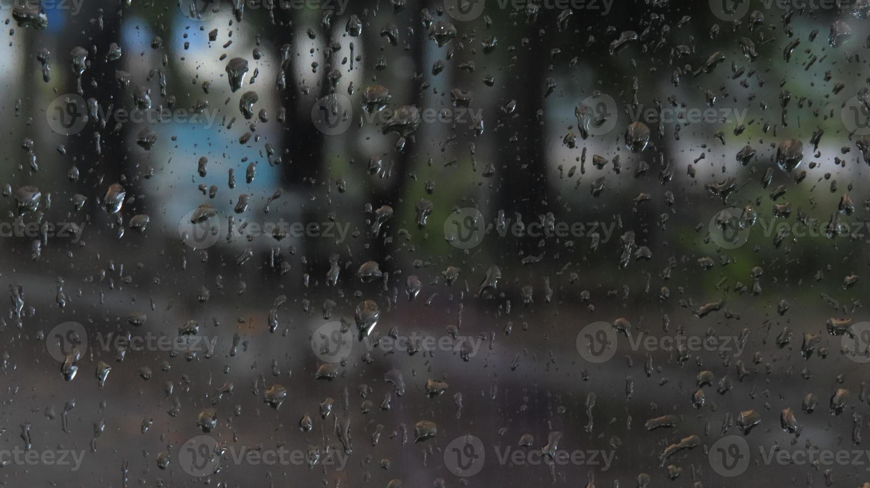Raindrops on the glass. Drops flow down the glass closeup. photo