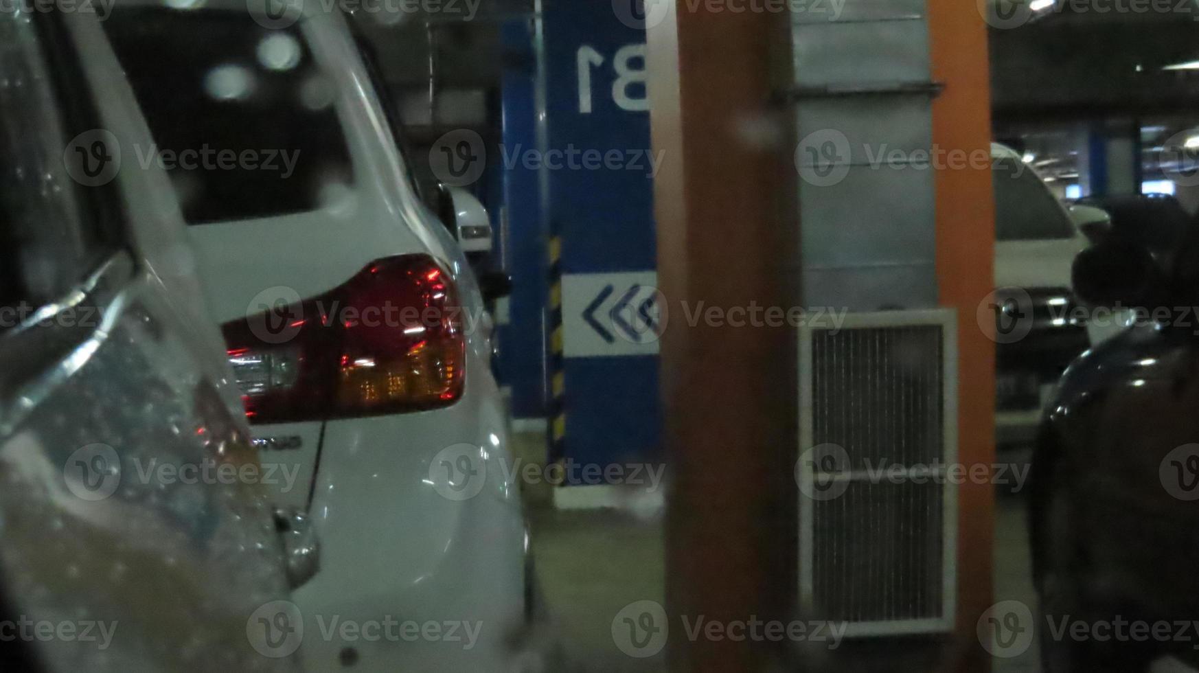 car in rear view mirror at parking lot photo