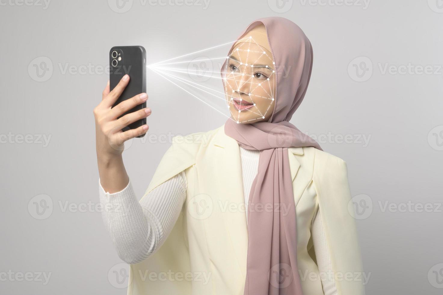 Beautiful woman is scanning her face with facial recognition system Smart phone photo