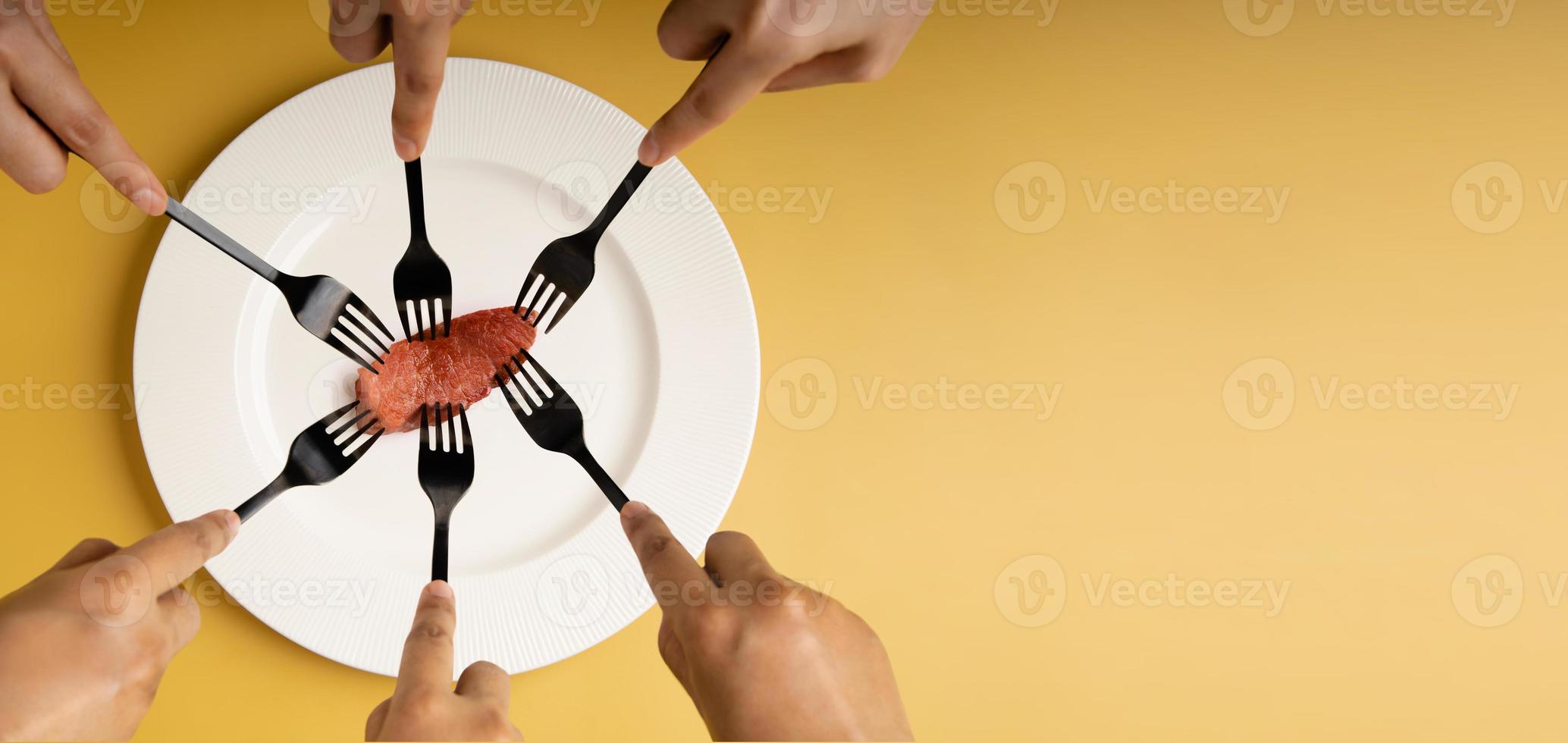 Food Shortage, World Food Crisis Concepts. Inflation, Fuel Price and Environmental Impact. Global Issues in Agricultural Production. Group of Hungry People Snatched a Tiny Steak by Fork photo