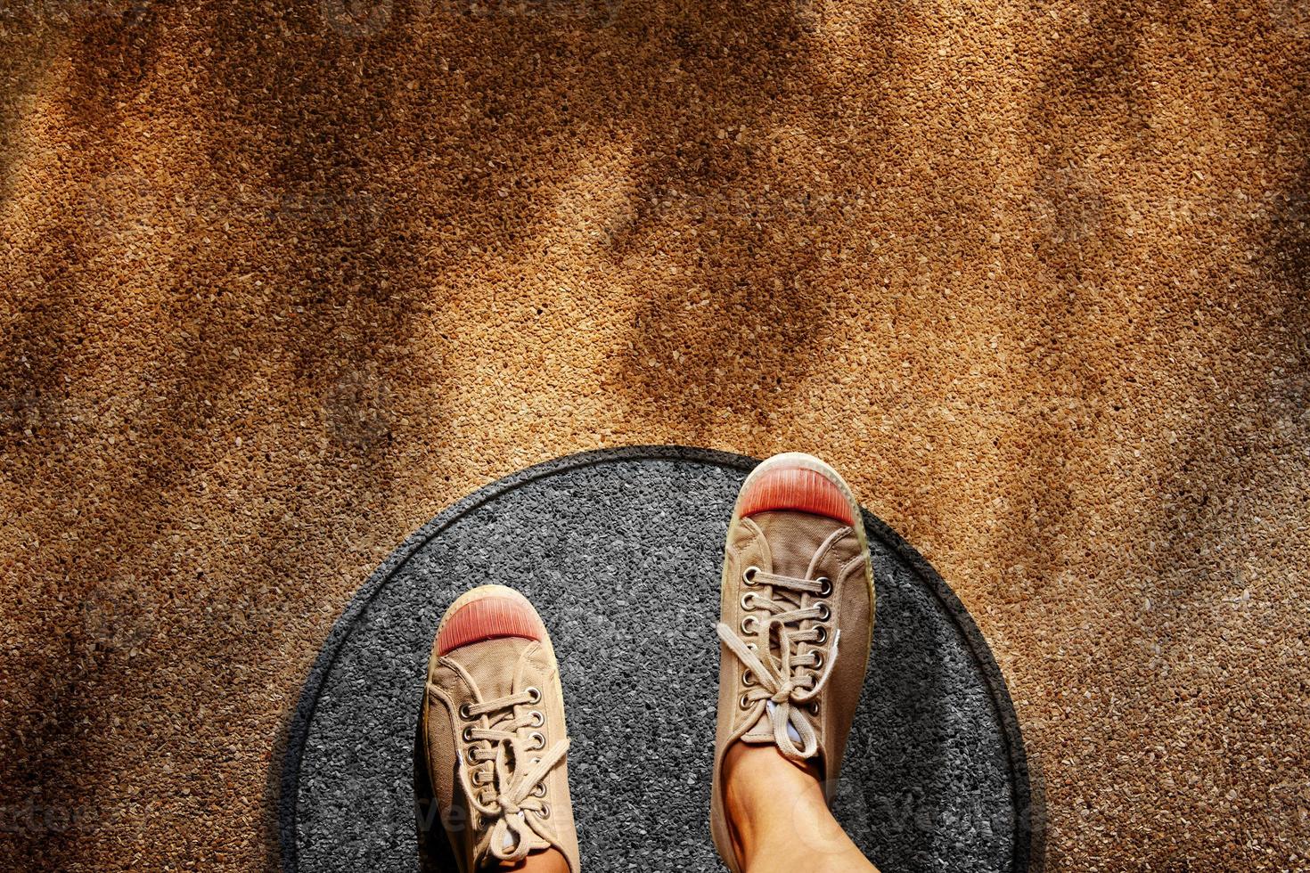 Comfort Zone Concept. Male on Sneaker Shoes Steps over Circle Line to Outside Bound, Top View, Grunge Dirty Concrete Floor with Sunlight as background photo