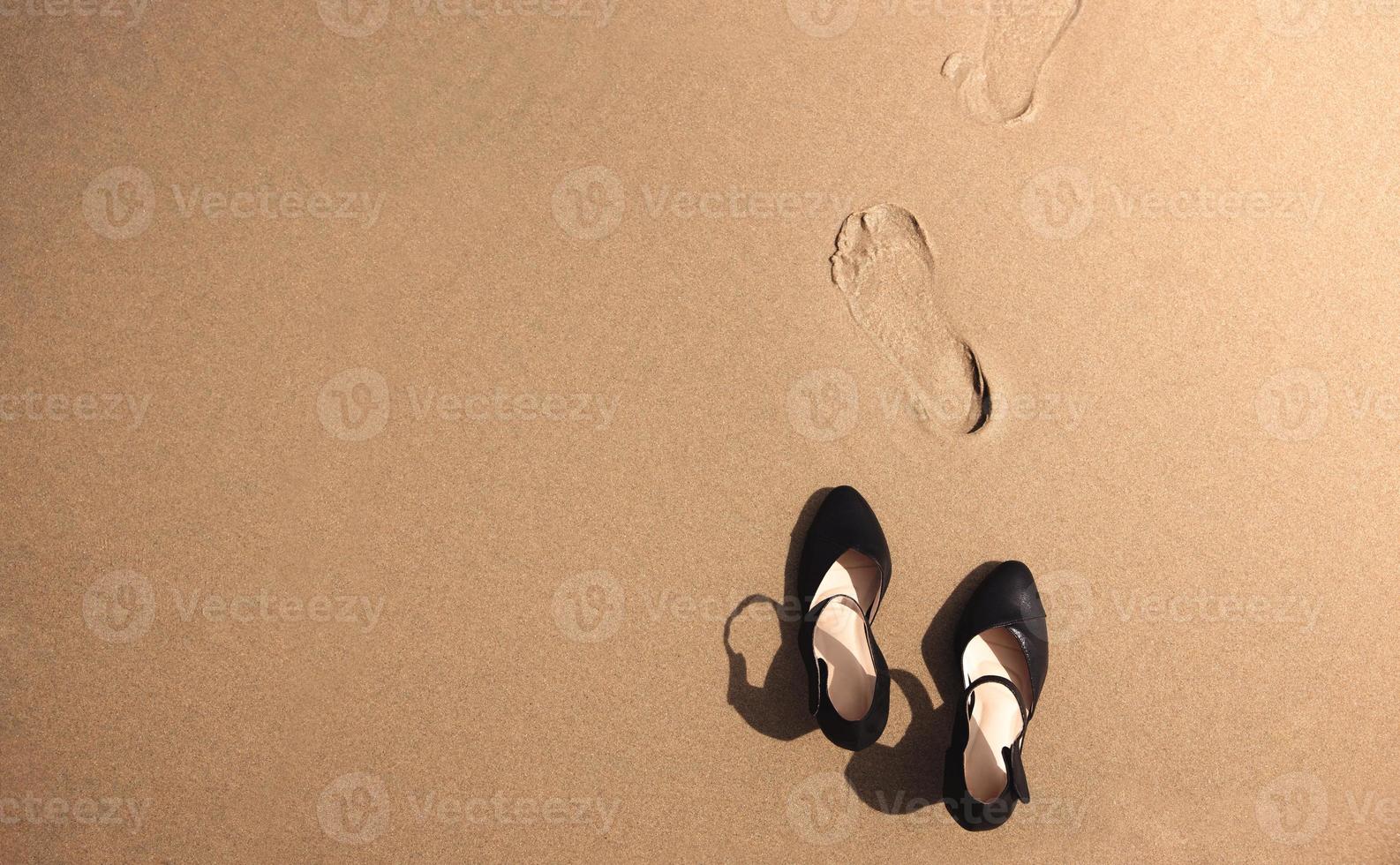 Work Life Balance Concept. Business Woman take off her Working Shoes and leave it on the Sand Beach for Walk into the Sea on Sunny Day. Quit a Job, Office Outing or Summer Vacation. Top View photo