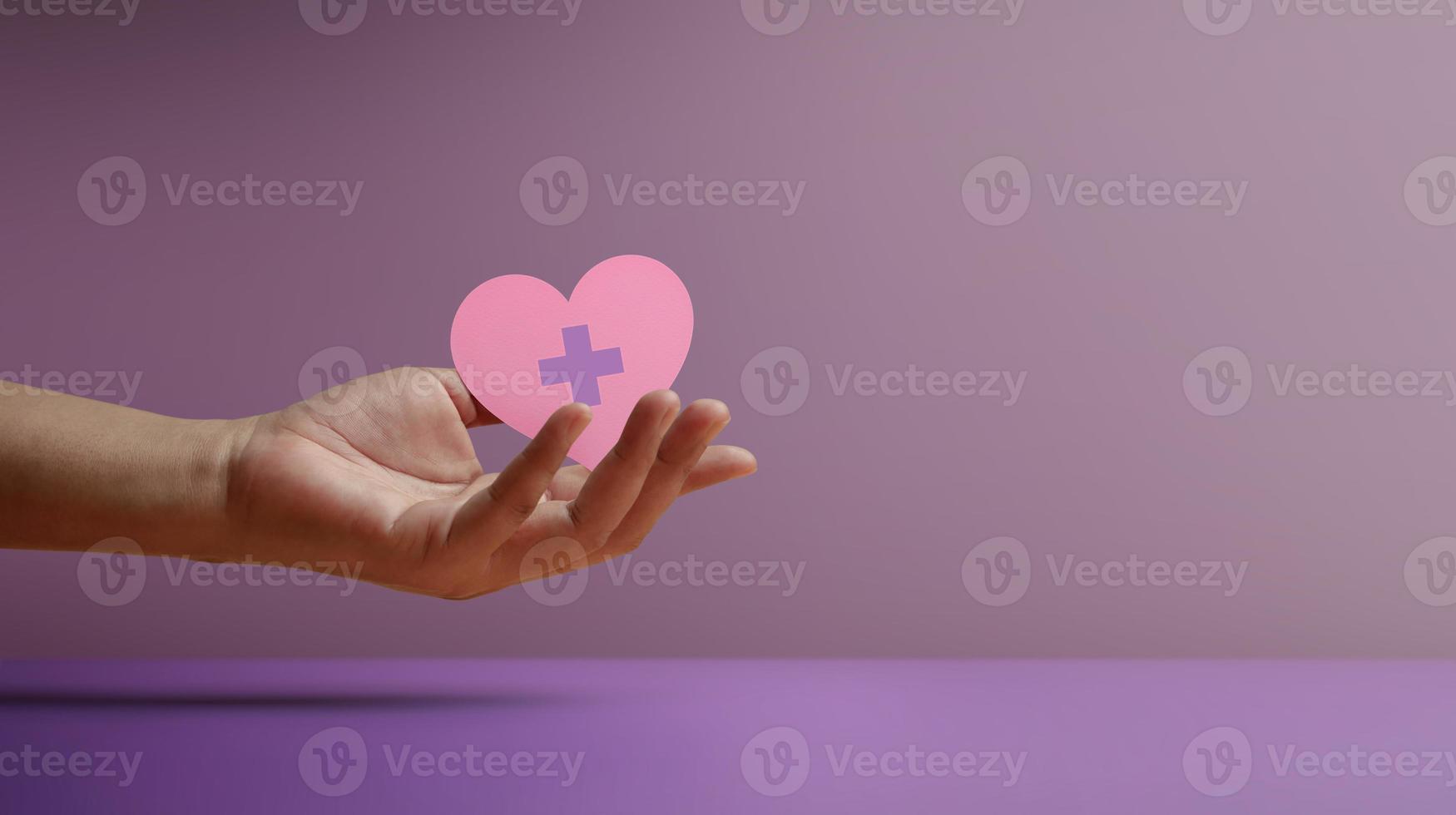 Donation Concepts. Hands of Volunteer Holding a Heart Shape with a Red Cross Sign. Love, Health Care, Donation and Charity. Side View photo