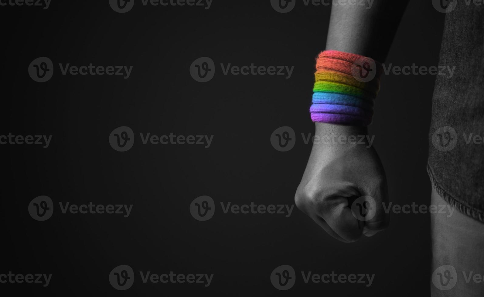 Power, Protest and Expression for LGBTQ, Rights Concept. Closeup of Fist and Rainbow Wrist Strap. Angry, Ready to Punch. Cropped and Selective Focus photo