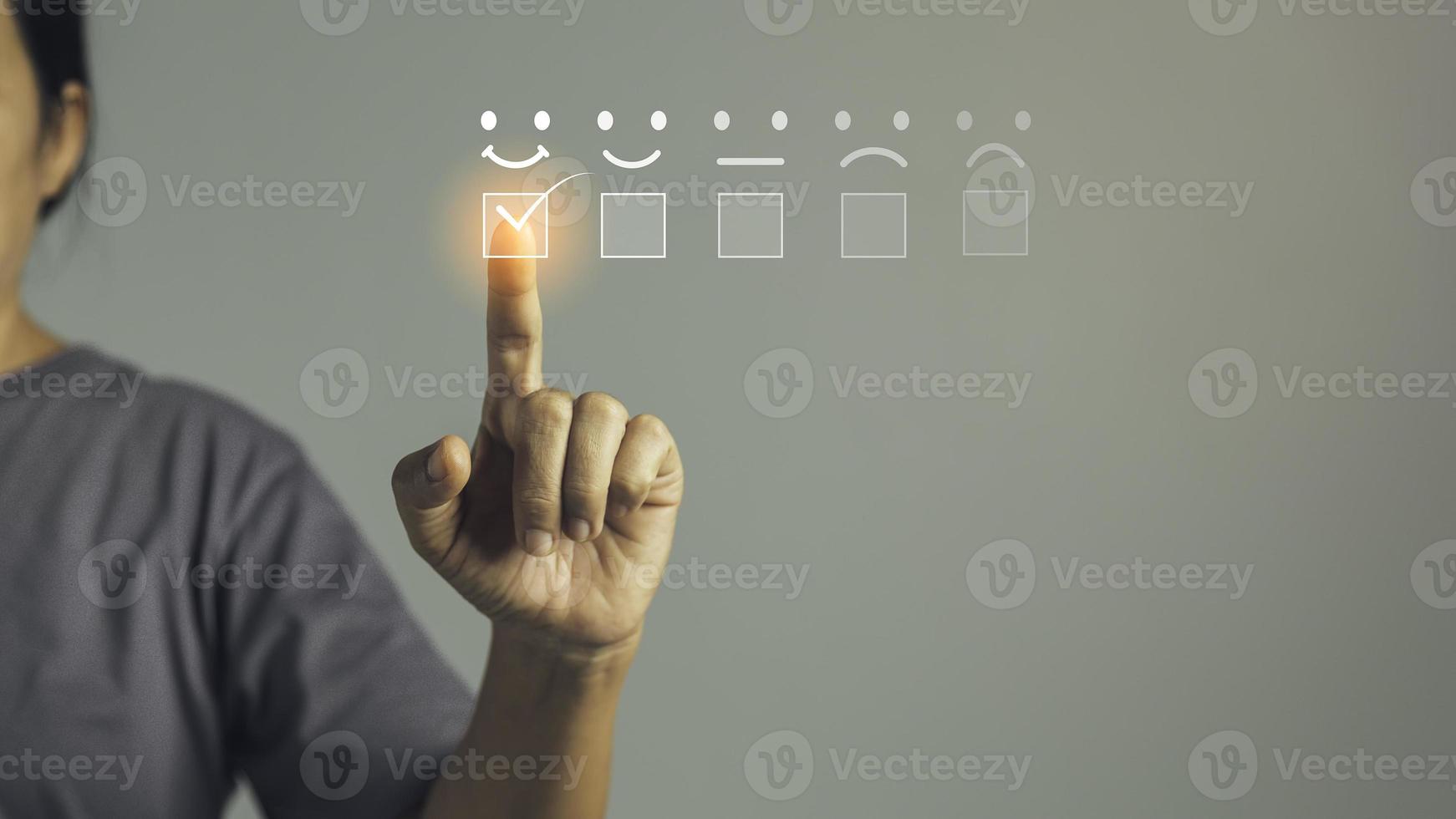 servicio al cliente y concepto de satisfacción, la persona de negocios está tocando la pantalla virtual en el icono de la cara sonriente feliz para dar satisfacción en el servicio. calificación muy impresionado. retroalimentación del servicio al cliente. foto