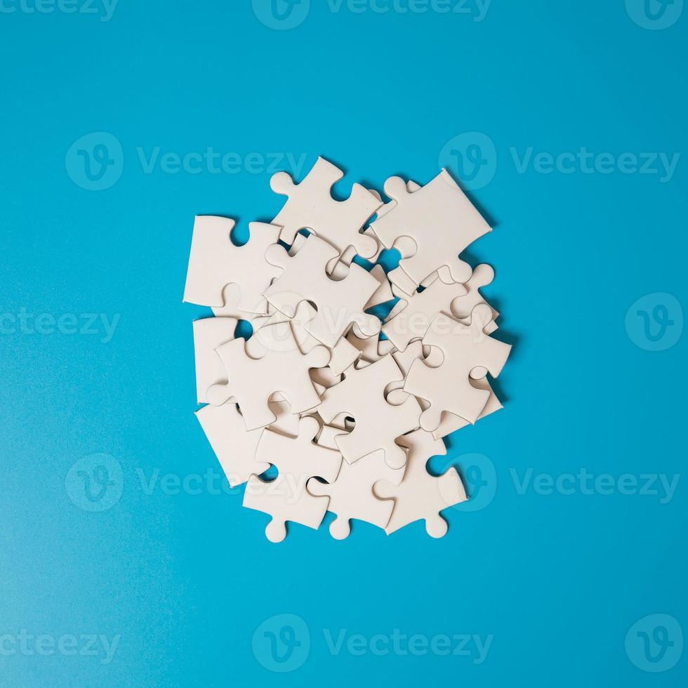 White part of jigsaw puzzle pieces on blue background. concepts of problem solving, business success, teamwork, Team playing jigsaw game incomplete, Texture photo with copy space for text