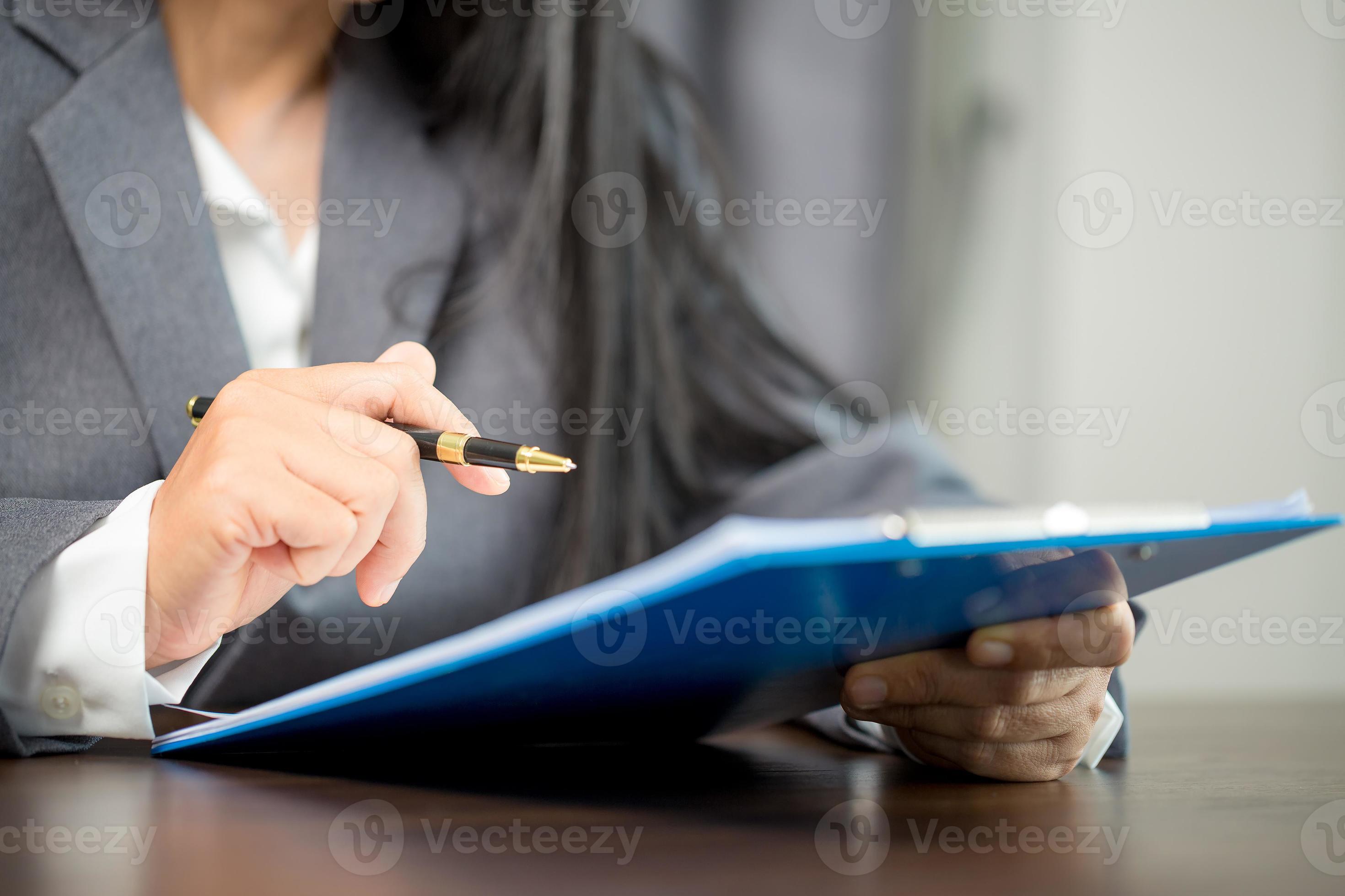 Workplace closeup person professional businesswoman sitting at desk hold pen signing or