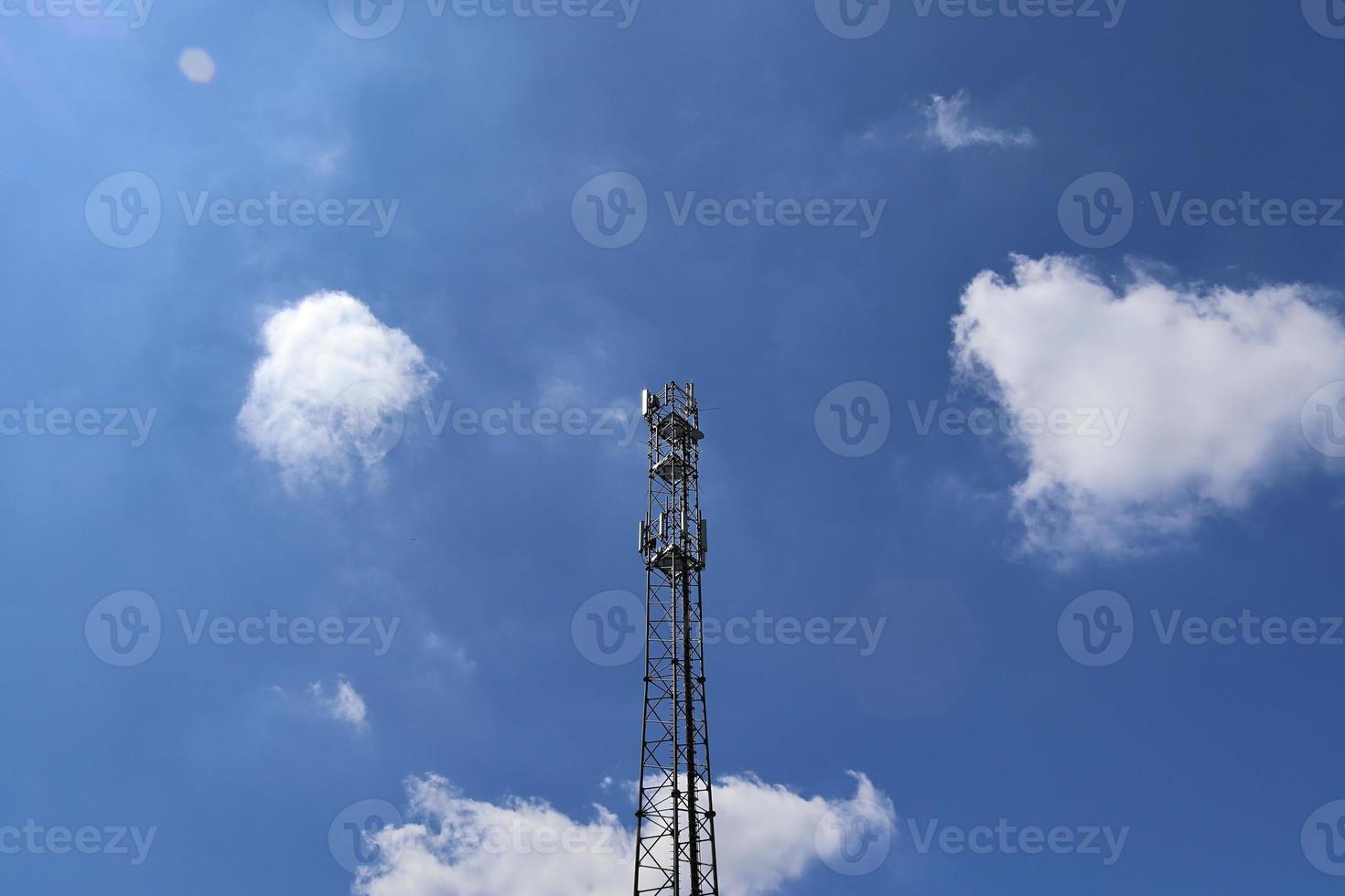 Electric antenna and communication transmitter tower in a northern european landscape against a blue sky photo
