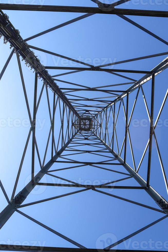 Antena eléctrica y torre transmisora de comunicaciones en un paisaje del norte de Europa contra un cielo azul foto