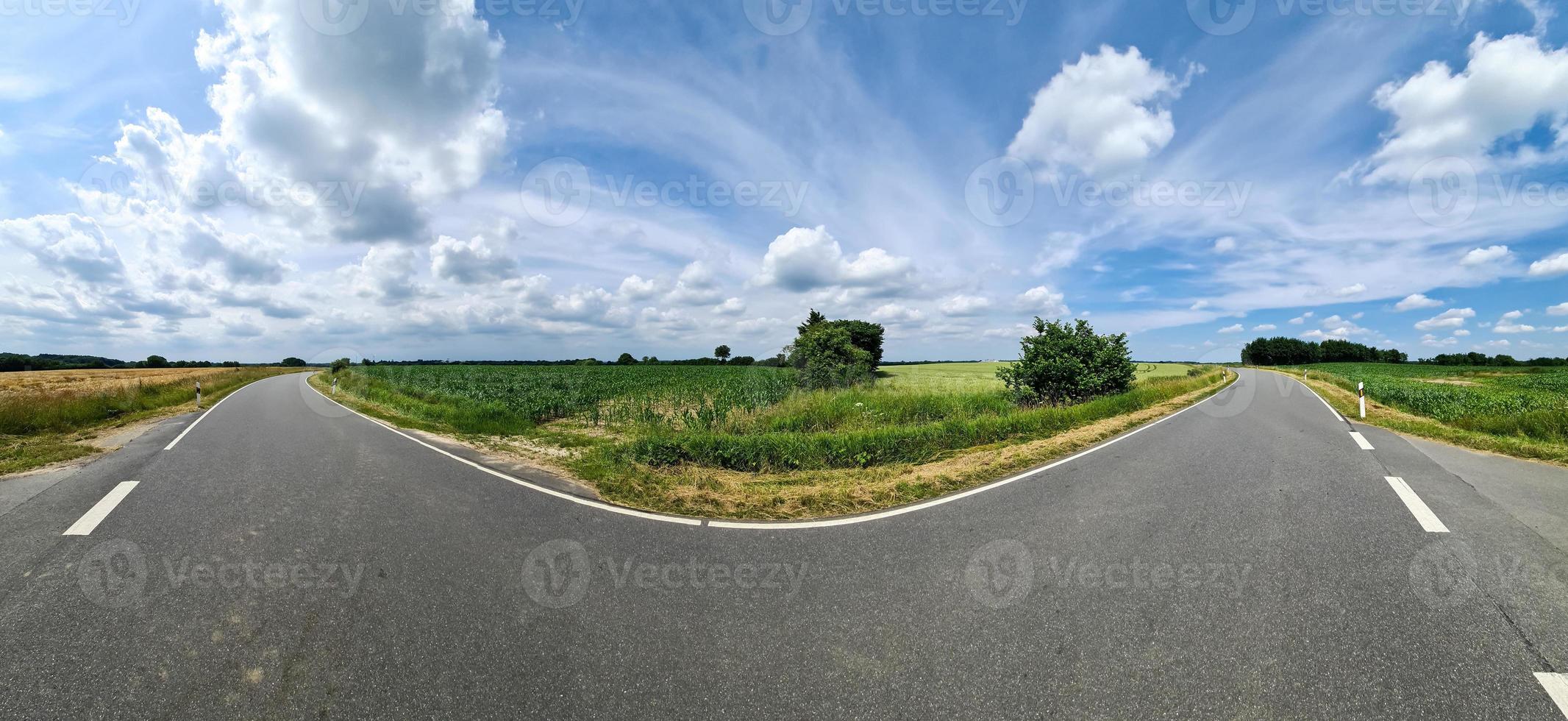 Beautiful high resolution panorama of a northern european country road with fields and green grass. photo