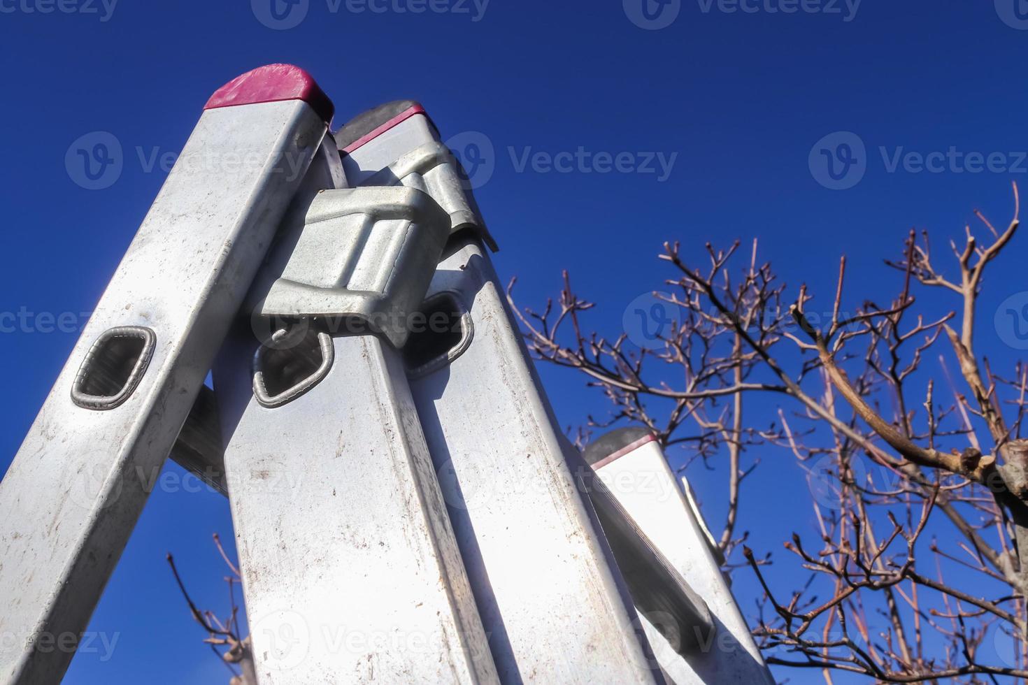 The top of an aluminum ladder against blue sky. photo