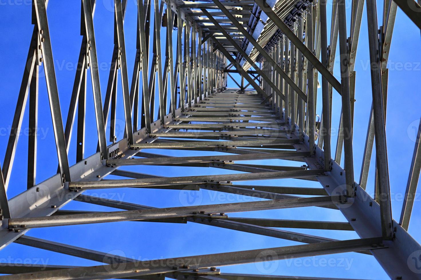 Electric antenna and communication transmitter tower in a northern european landscape against a blue sky photo