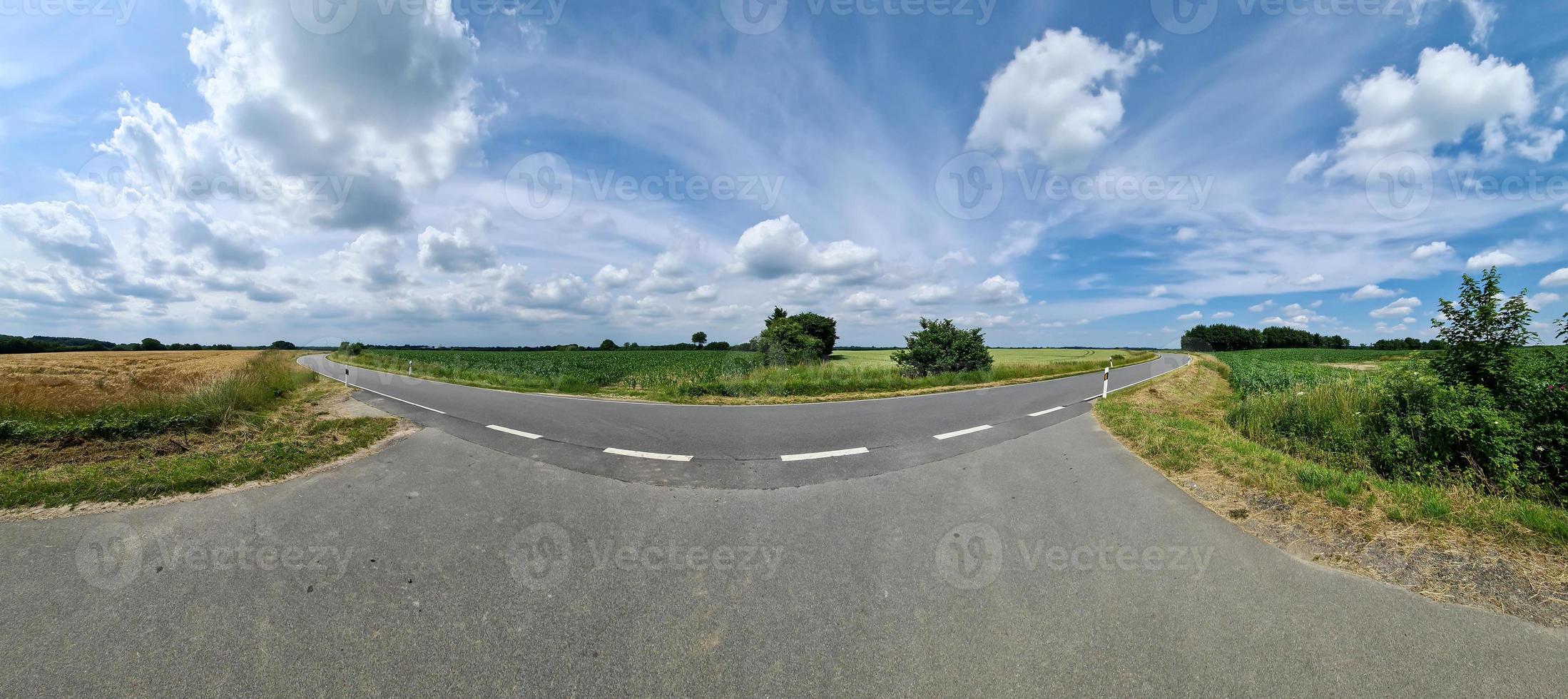 Beautiful high resolution panorama of a northern european country road with fields and green grass. photo