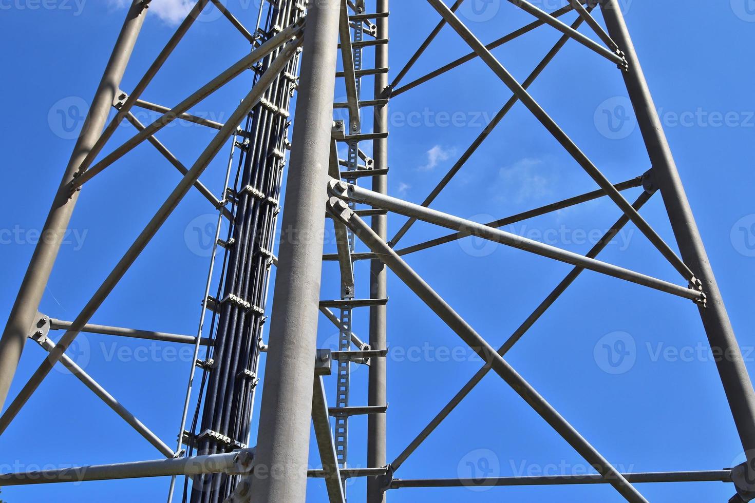 Electric antenna and communication transmitter tower in a northern european landscape against a blue sky photo