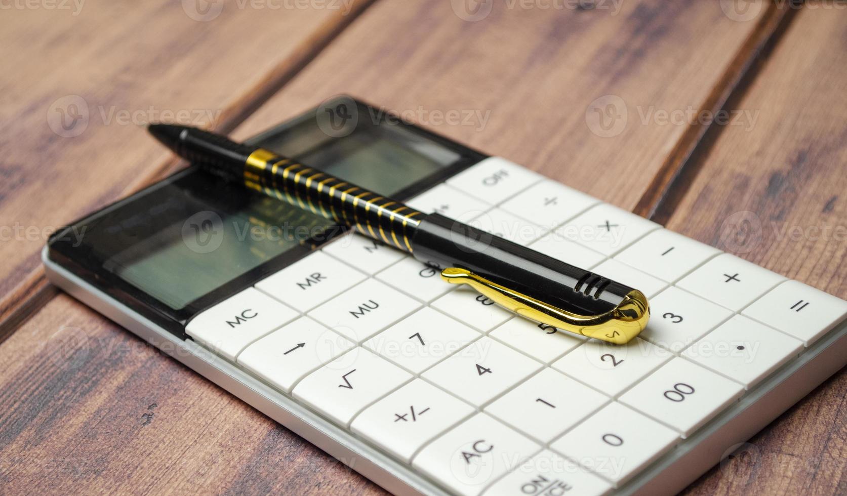 Financial accounting with calculator and pen on wooden desk photo