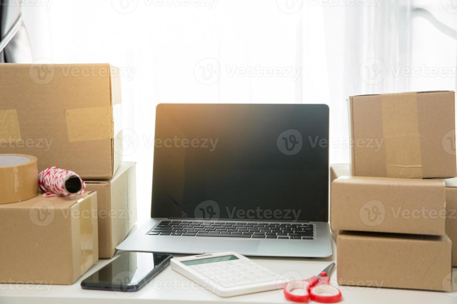 Equipments for SME online business, delivery business laptop, barcode, boxes, checking product on stocks or cardboard parcels. Small business working at home office. delivery service product at home. photo