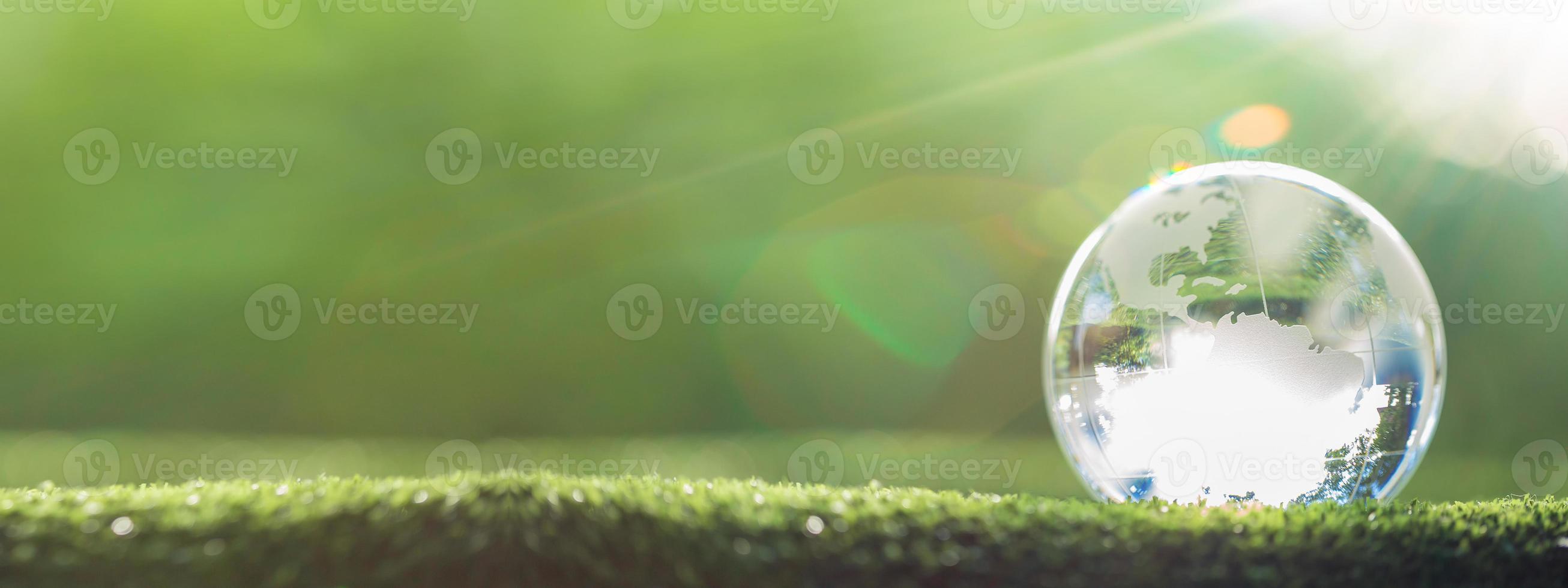 Globe planet glass In green forest with bokeh nature lights. world environment day. concept for environment conservation, protect ecology earth and environmental eco-friendly life with copy space photo