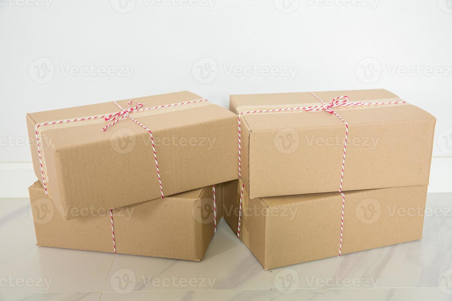 Stack of cardboard boxes for moving, Empty room with a white wall and cardboard boxes with unbranded barcode on the floor. Delivery of goods, shopping. Cardboard boxes on gray wall background. photo