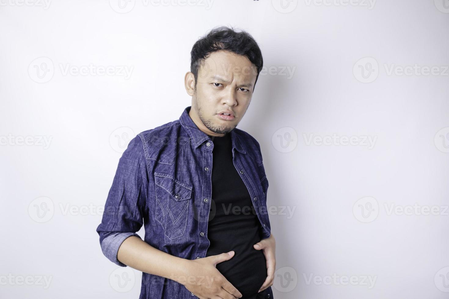 A portrait of insecure Asian fat man is holding the fat around his waist photo