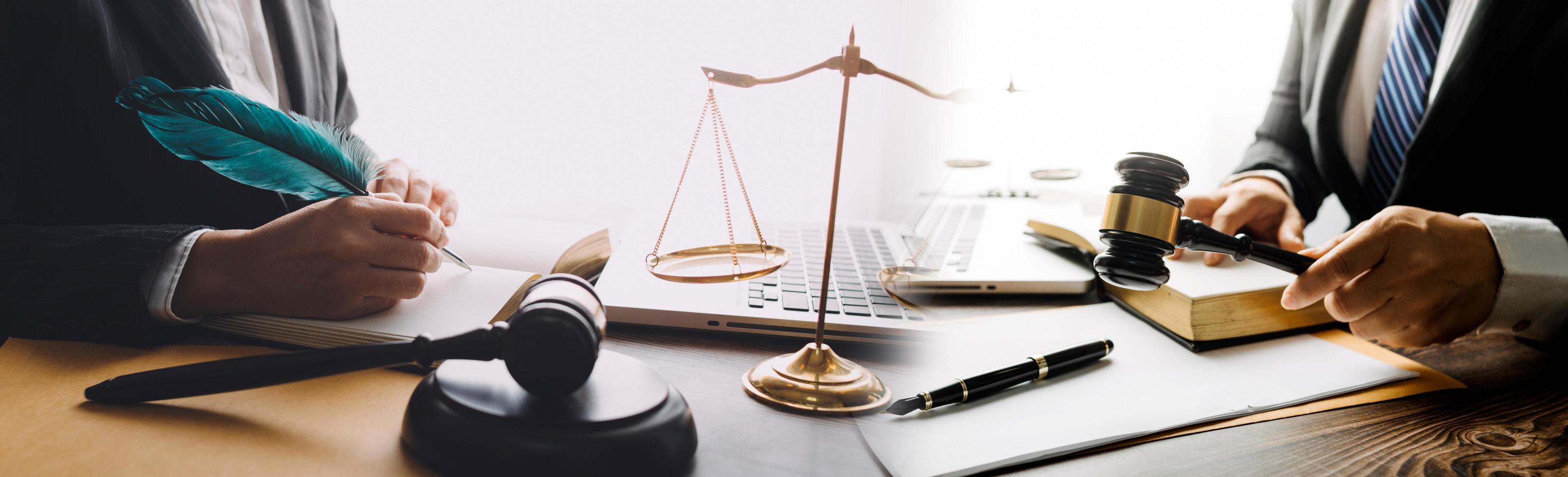 Justice and law concept.Male judge in a courtroom with the gavel, working with, computer and docking keyboard, eyeglasses, on table in morning light photo