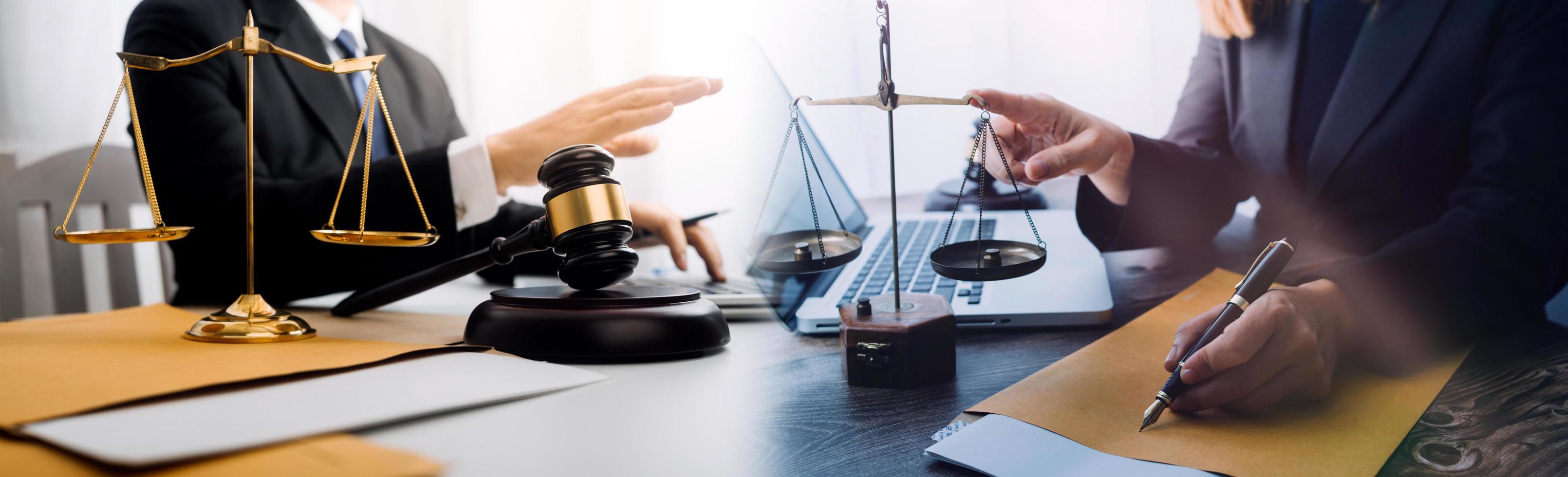 Business and lawyers discussing contract papers with brass scale on desk in office. Law, legal services, advice, justice and law concept picture with film grain effect photo