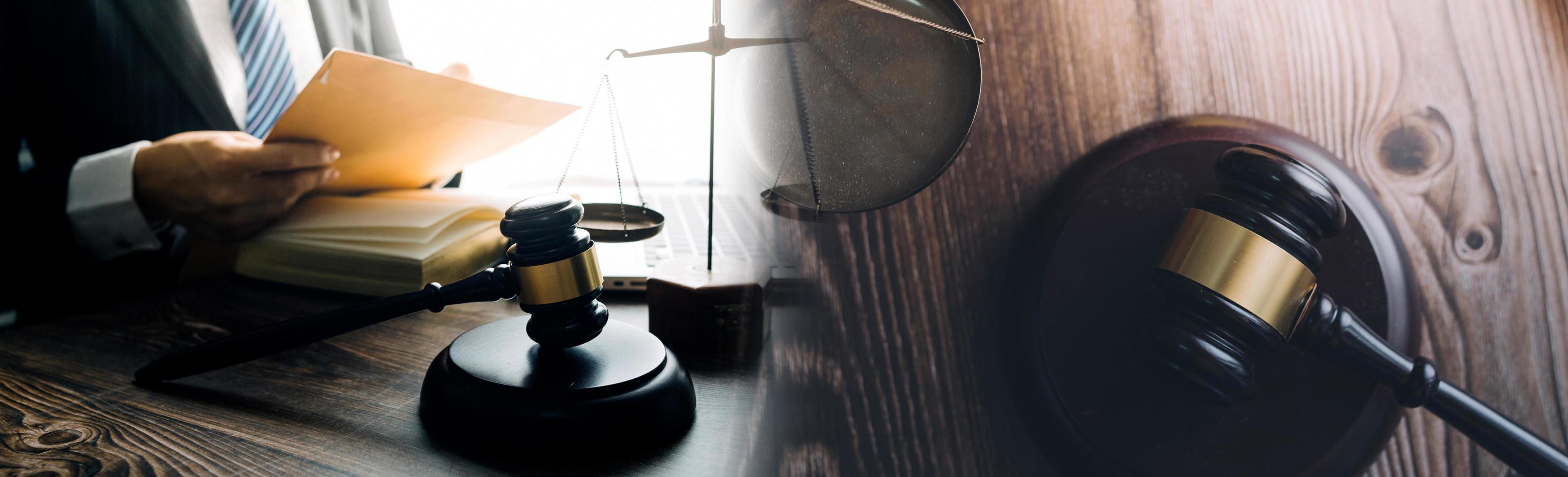 Justice and law concept.Male judge in a courtroom with the gavel, working with, computer and docking keyboard, eyeglasses, on table in morning light photo