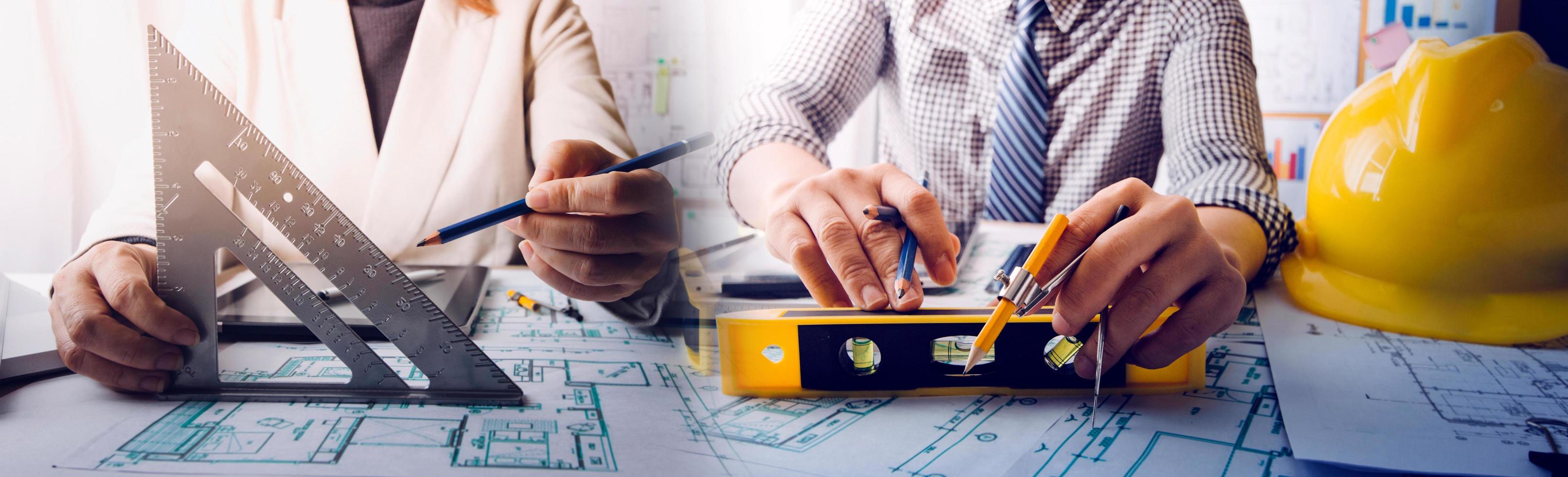 Two colleagues discussing data working and tablet, laptop with on on architectural project at construction site at desk in office photo