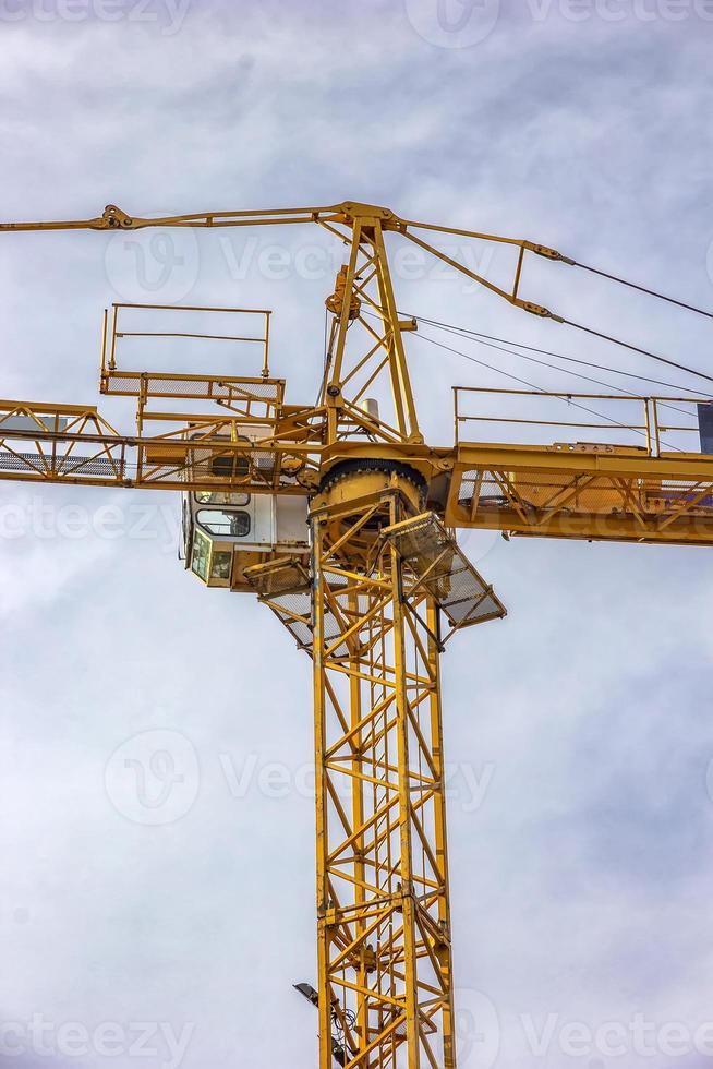 Construction tower crane, cabin, closeup, on blue sky with