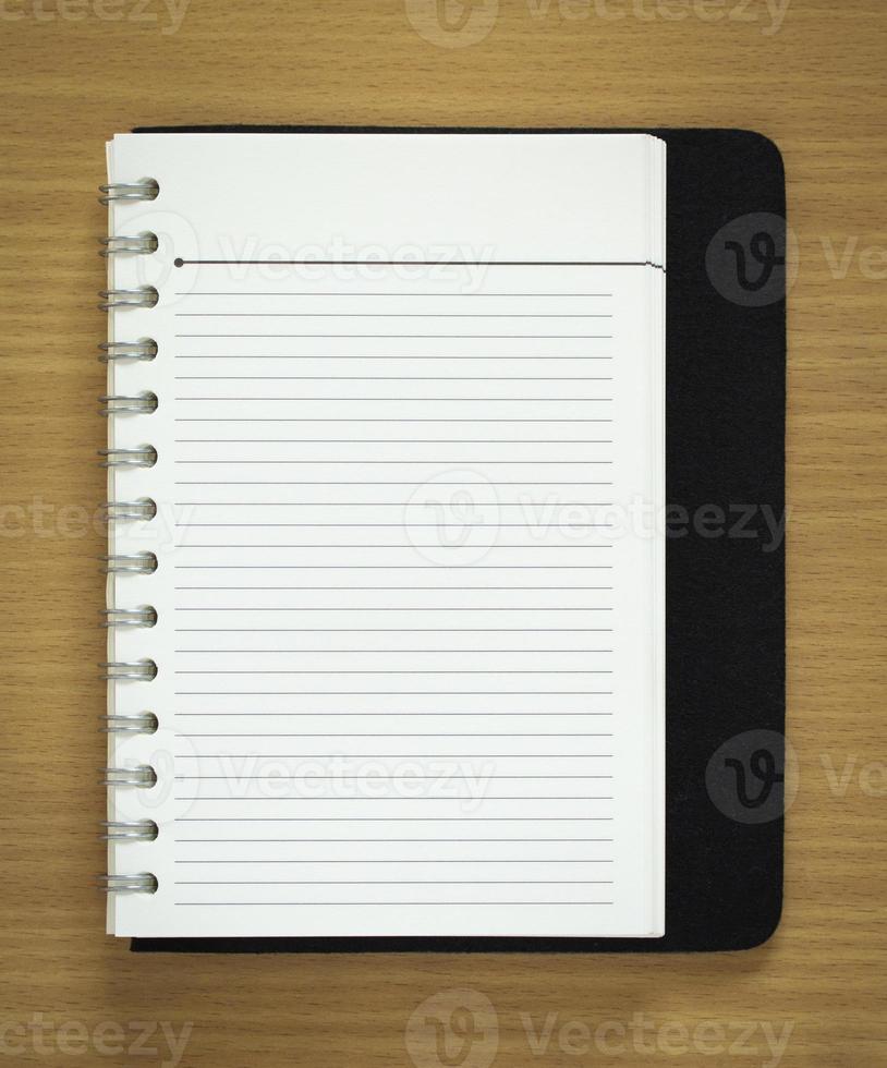 blank spiral notepad on wood background photo