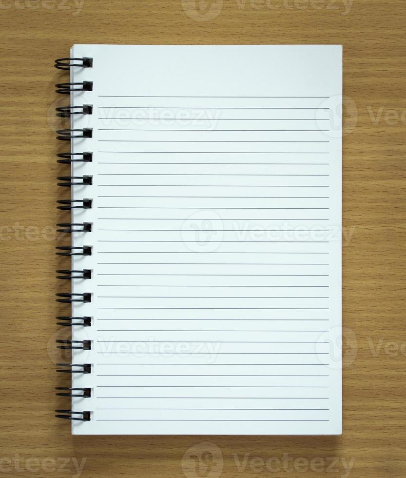 blank spiral notepad on wood background photo