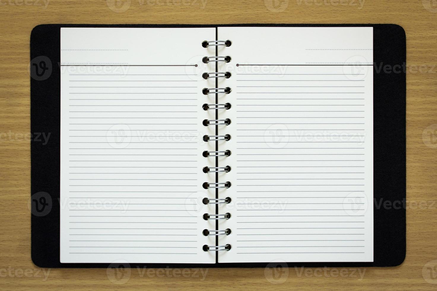 blank spiral notebook on wood background photo