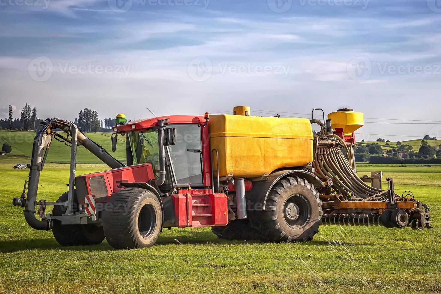 heavy tractor for application of manure on arable farmland at the field in Germany photo