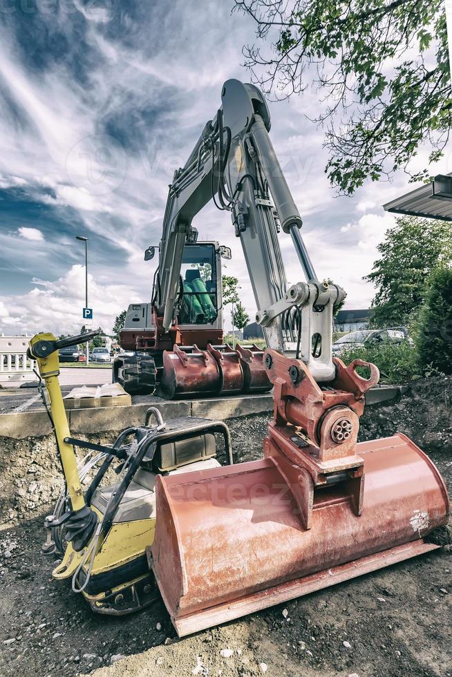 A stopping excavator at the construction site. Vintage view photo