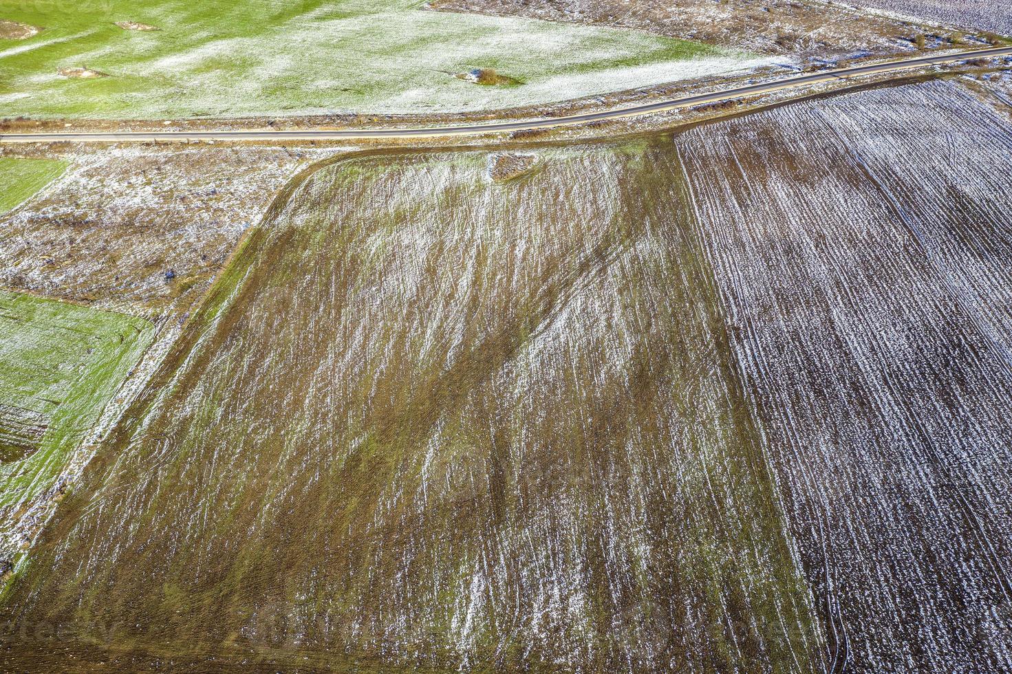 Fields with winter crops and plowed field. Fields covered with snow. Aerial view. photo