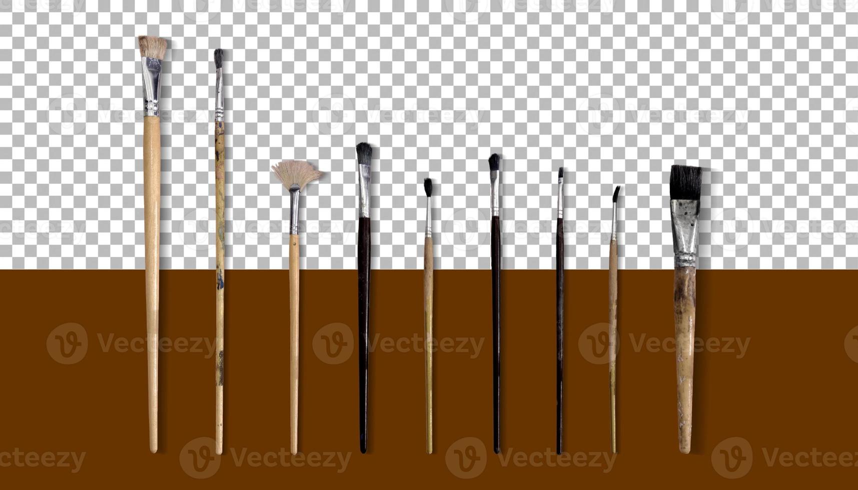 Set of different brushes isolated on wooden background. photo
